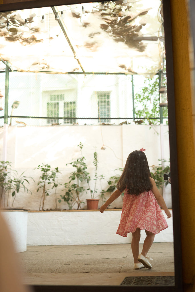 pretty-girl-in-halter-neck-summer-dress-in-pink-floral-handblock-print-with-buttons-at-the-back