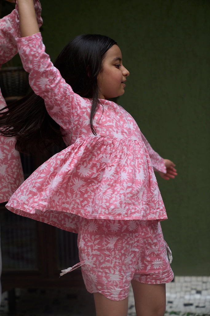 little-girl-twirling-and-dancing-in-a-pink-floral-fullsleeve-coord-set-with-shorts-handblock-printed-in-Jaipur