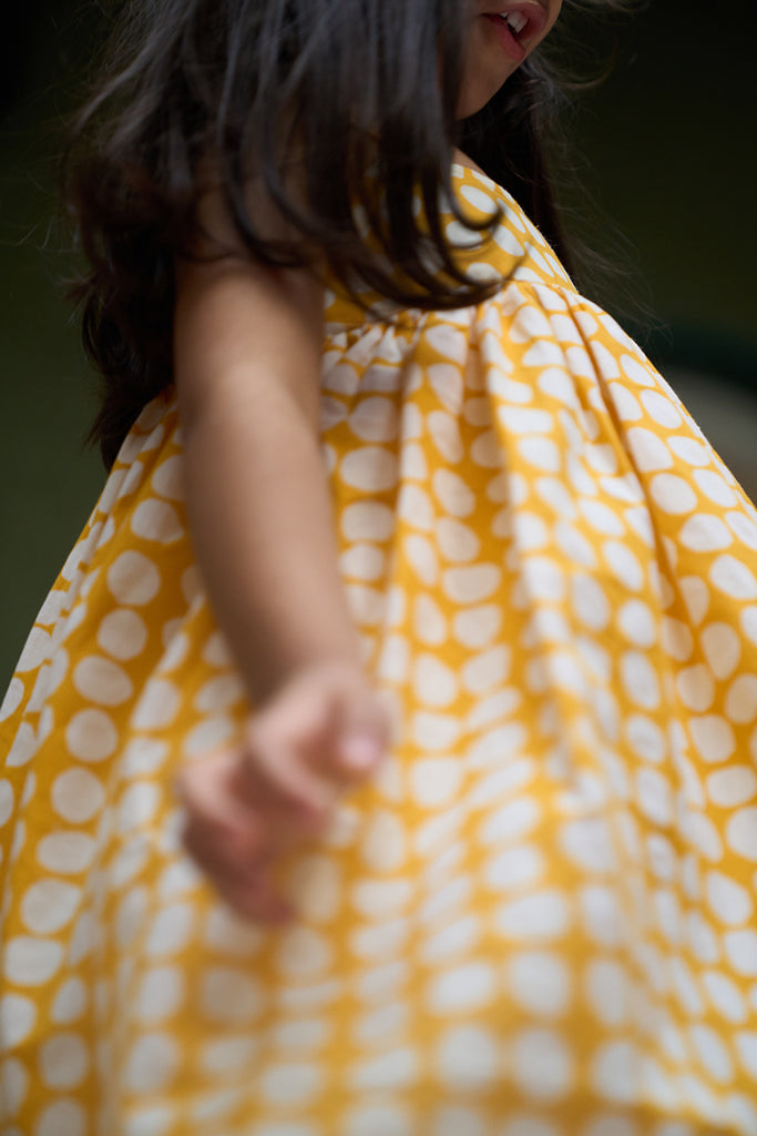 cute-little-girl-twirling-and-dancing-in-girls-kurta-coord-set-in-yellow-polka-hand-block-print-and-cotton-dhoti-pant