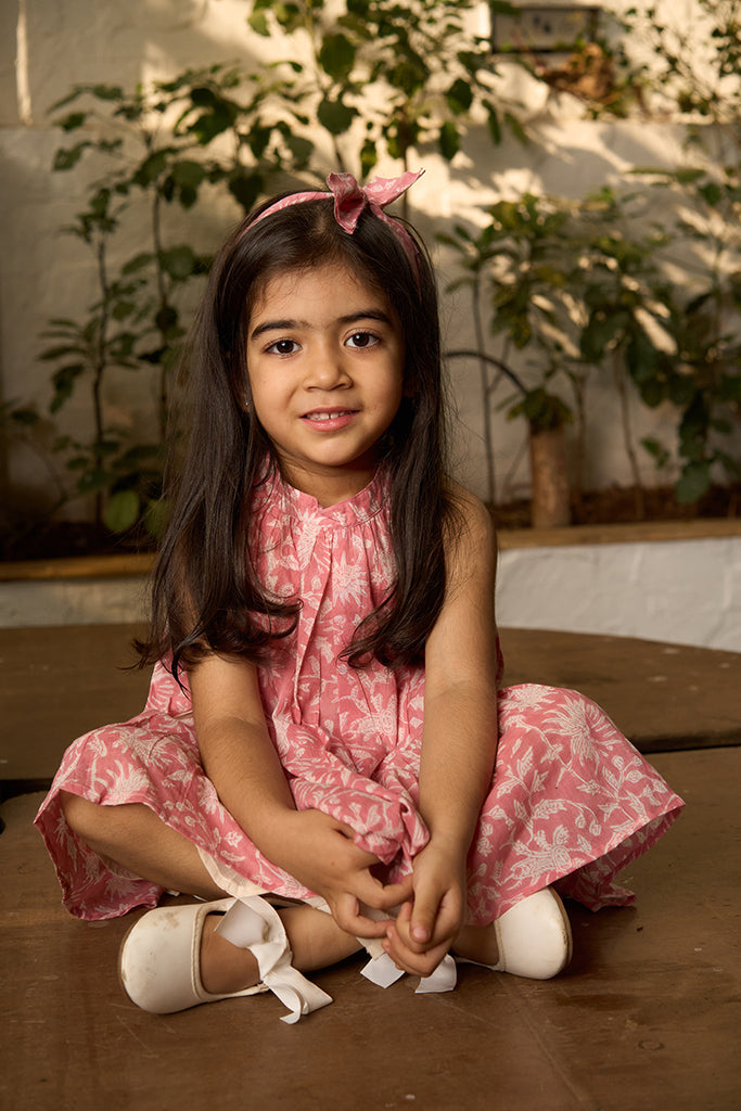 pretty-girl-in-halter-neck-summer-dress-in-pink-floral-handblock-print-with-buttons-at-the-back