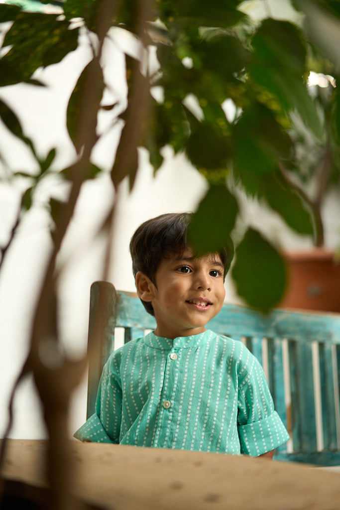 Little-boy-in-Lovetheworldtoday's-classic-Barefoot-Boy-mandarin-collar-hand-block-printed-cotton-unisex-full-sleeve-summer-shirt-in-blue-with-white-polka-dots-for-boys-and-girls