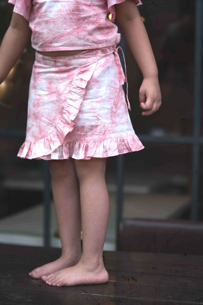 Little girl in pink wrap around skirt made with organic cotton and natural dye. 