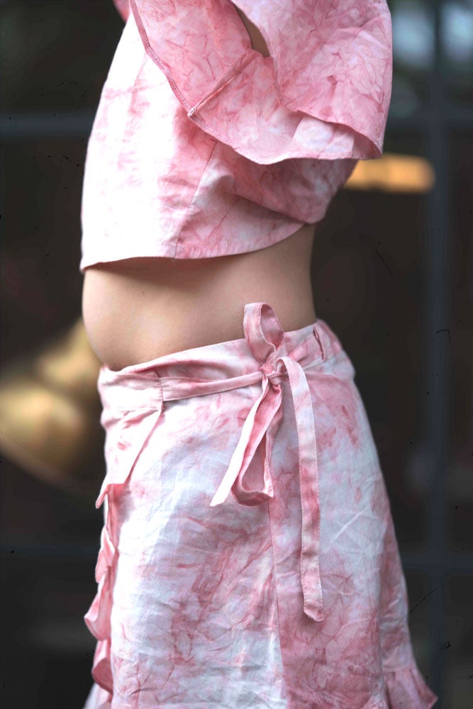 Little girl in pink wrap around skirt made with organic cotton and natural dye. 